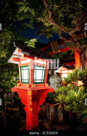 Eine traditionelle japanische Laterne, beleuchtet bei Nacht auf Shinbashi-dori, Kyoto, Japan. Die leuchtenden Rot- und Grüntöne bilden einen schönen Kontrast zum lu Stockfoto