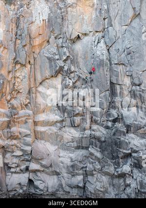 Bergsteiger können auf einer zerklüfteten Felswände traditionell klettern und dabei Ausdauer und Geschicklichkeit unter Beweis stellen. Die majestätischen Klippen und die natürliche Umgebung bilden ein Th Stockfoto