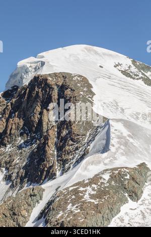 Atemberaubender Sommerblick auf die schneebedeckten Gipfel in Zermatt, Schweiz. Das zerklüftete Gelände und die eisigen Gletscher zeigen die majestätische Schönheit der Alp Stockfoto