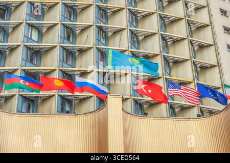 Almaty, Kasachstan - 14. Juli 2025: Die Staatsflagge Kasachstans und die Flaggen anderer Länder auf dem Dach des Hotels. Tourismusentwicklung Stockfoto