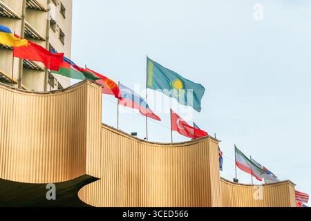Almaty, Kasachstan - 14. Juli 2025: Die Staatsflagge Kasachstans und die Flaggen anderer Länder auf dem Dach des Gebäudes. Freundschaft der Völker Stockfoto