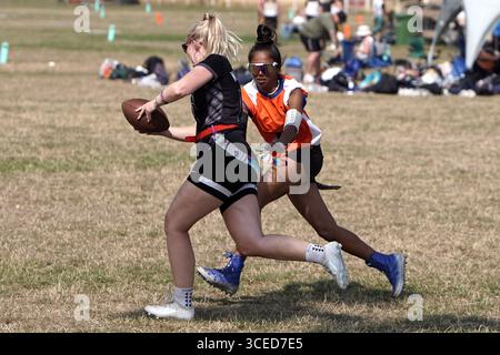 Fahnenfußballspielerin, die mit dem Ball läuft @ Flagapalooza 2025 Flag Football Tournament, Newlands Park, Cheltenham, Vereinigtes Königreich, Stockfoto