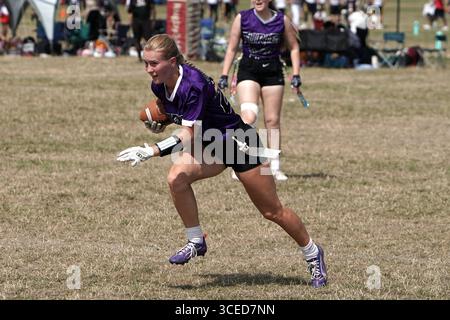 Weiße blonde Fahnenfußballspielerin, die mit dem Ball läuft @ Flagapalooza 2025 Flag Football Tournament, Newlands Park, Cheltenham, Vereinigtes Königreich, Stockfoto