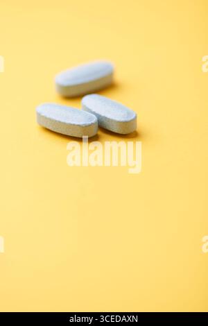 Multivitamintabletten auf hellem Papierhintergrund. Nahaufnahme. Kopierbereich Stockfoto