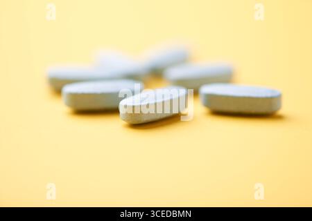 Multivitamintabletten auf hellem Papierhintergrund. Nahaufnahme. Kopierbereich Stockfoto