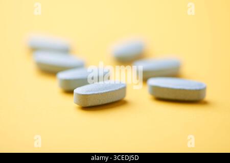 Multivitamintabletten auf hellem Papierhintergrund. Nahaufnahme. Kopierbereich Stockfoto