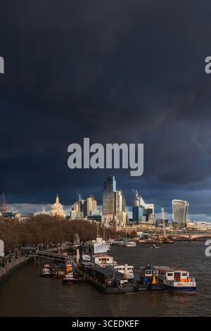 Blick auf die Themse mit dunklen, dramatischen Wolken über der Stadt, London, Großbritannien Stockfoto