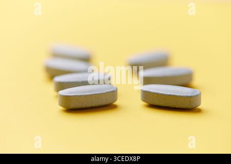 Multivitamintabletten auf hellem Papierhintergrund. Nahaufnahme. Kopierbereich Stockfoto