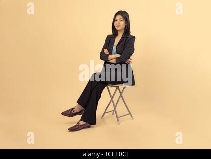 Selbstbewusste professionelle Frau in Geschäftskleidung vor neutralem Hintergrund Stockfoto