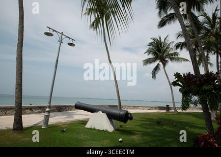 Eine Kanone in den Gärten, die auf das Meer zeigt, vor dem Eastern & Oriental (E&O) Hotel in Goerge Town, Hauptstadt Penang in Malaysia, dem C Stockfoto