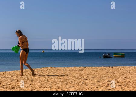 Frau, die am Strand in Badekleidung in Paradise Bay, Malta, läuft Stockfoto