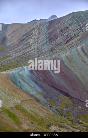 Der Palccoyo Rainbow Mountain entfaltet sich in atemberaubenden Farbschichten, einem versteckten Juwel in den peruanischen Anden. Im Gegensatz zu seinen berühmten Geschwistern, dieses heitere Wunder Stockfoto