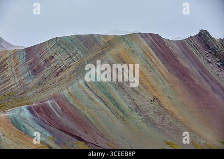 Der Palccoyo Rainbow Mountain entfaltet sich in atemberaubenden Farbschichten, einem versteckten Juwel in den peruanischen Anden. Im Gegensatz zu seinen berühmten Geschwistern, dieses heitere Wunder Stockfoto