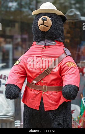 Vor einem Souvenirladen steht ein großer Stoffbär, der als kanadischer Mountie gekleidet ist, in roter Uniform und Hut Stockfoto