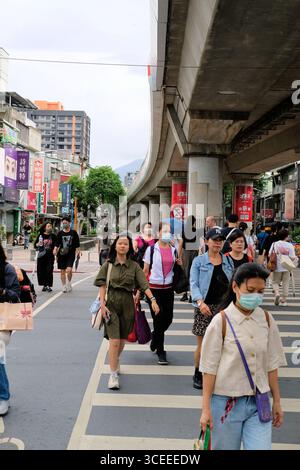 Fußgänger auf einem Fußgängerübergang im Shiliin District, Taipei, Taiwan; urbane Straßenszene mit lokalen taiwanesischen Stadtstraßen. Stockfoto