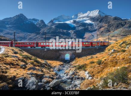 Bernina Express Zug überquert Alpenlandschaft mit Gletscher Stockfoto