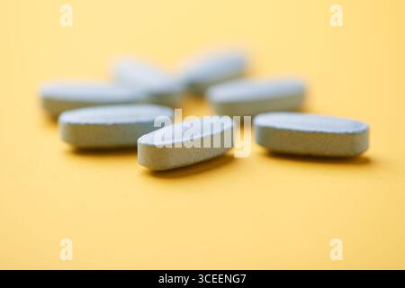 Multivitamintabletten auf hellem Papierhintergrund. Nahaufnahme. Kopierbereich Stockfoto
