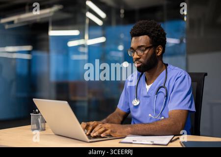 Medizinisches Fachpersonal, das im Büro sitzt, mit einem Laptop abgewischt wird. Stockfoto