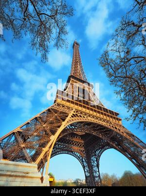Der Eiffelturm, vom Boden aus gesehen in Paris, Frankreich, schafft einen Fluchtpunkt, der den Blick nach oben zieht Stockfoto