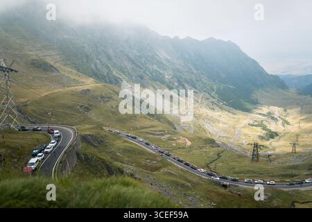 Autos stehen an bewölkten Tagen auf einer gewundenen Bergstraße Stockfoto