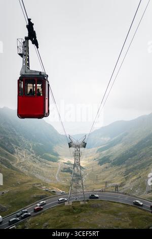 Rote Seilbahn über gewundene Bergstraße im transfagarasan Pass Stockfoto