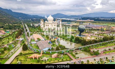 Atemberaubender Blick aus der Luft auf den Jaime Duque Park in Briceño, Bogotá, mit Dinosaurierskulpturen und ikonischer Architektur inmitten üppiger Vegetation. Stockfoto
