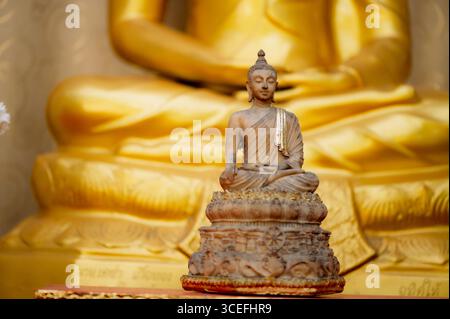 Der Lord Buddha meditierte anmutig über eine Lotusblume mit orangefarbenem Hintergrund. (Über Den Buddhismus) Stockfoto