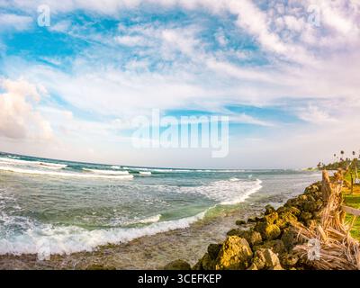 Ruhige Küstenszene von San Andres Island mit Wellen, felsigem Ufer und lebendigem Himmel, perfekt für Reise- und Naturliebhaber. Stockfoto
