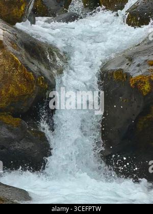 Rauschendes Wasser strömt über die Felsen am Oxararfoss Wasserfall. Stockfoto