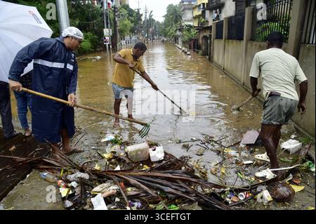 Guwahati, Guwahati, Indien. August 2025. Arbeiter, die die überflutete Straße nach Regen in Guwahati Indien am Sonntag, den 17. August 2025 reinigen (Foto: © Dasarath Deka/ZUMA Press Wire) NUR REDAKTIONELLE VERWENDUNG! Nicht für kommerzielle ZWECKE! Quelle: ZUMA Press, Inc./Alamy Live News Stockfoto