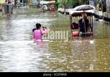 Guwahati, Guwahati, Indien. August 2025. Eine Frau wate durch die überflutete Straße nach Regen in Guwahati Indien am Sonntag, den 17. August 2025 (Foto: © Dasarath Deka/ZUMA Press Wire) NUR REDAKTIONELLE VERWENDUNG! Nicht für kommerzielle ZWECKE! Quelle: ZUMA Press, Inc./Alamy Live News Stockfoto