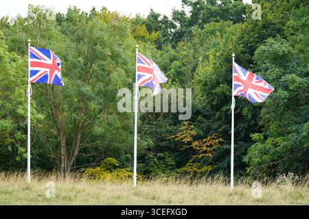 Drei britische Flaggen fliegen in einer grünen Landschaft. Broadway, England Stockfoto