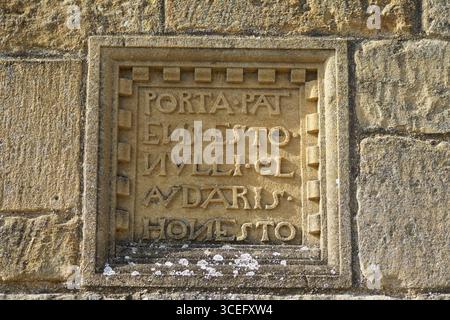 Alte Steininschrift an der historischen Mauer mit dekorativem Randdetail. Broadway, England Stockfoto