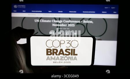 Deutschland. August 2025. In dieser Fotoabbildung hält eine Person ein Handy mit dem Logo der UN-Klimakonferenz COP30 in Brasilien auf dem Bildschirm vor der Webseite. (Foto von Timon Schneider/SOPA Images/SIPA USA) *** ausschließlich für redaktionelle Nachrichten *** Credit: SIPA USA/Alamy Live News Stockfoto