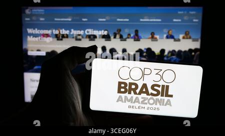 Deutschland. August 2025. In dieser Fotoabbildung hält eine Person ein Mobiltelefon mit dem Logo der UN-Klimakonferenz COP30 in Brasilien auf dem Bildschirm vor der Webseite. (Foto von Timon Schneider/SOPA Images/SIPA USA) *** ausschließlich für redaktionelle Nachrichten *** Credit: SIPA USA/Alamy Live News Stockfoto