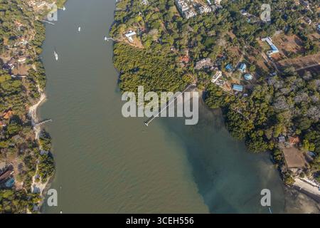 Aus der Vogelperspektive auf das ruhige Wasser des Mtwapa Creek, das den Himmel reflektiert, umgeben von grünen Mangrovenwäldern und den Sandstränden der kenianischen Küste, Mombasa, Mombasa County, Kenia. Stockfoto