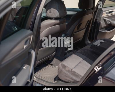 Detaillierte Aufnahme der Rücksitze in einem modernen Auto mit schwarzer Polsterung, geräumigem Innenraum und funktionalen Belüftungsdüsen. Ideal für Automobil- und Reiseanwendungen Stockfoto