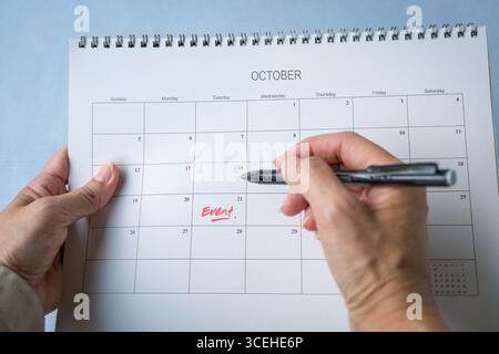 Frau, die ein Ereignis überprüft, das im Kalender aufgeführt ist. Konzept der Veranstaltungsplanung. Nahansicht. Stockfoto
