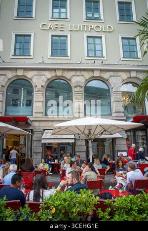 Menschen, die vor dem traditionellen Kaffeehaus des Café Luitpold in München sitzen. Stockfoto