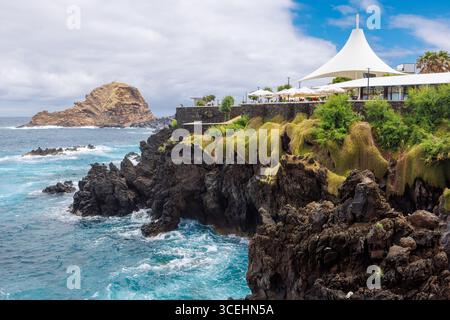 Porto Moniz, Madeira - 7. Juli 2025; wunderschöner Blick auf die Klippen der vulkanischen Pools, große Markise über den Tischen auf der Aussichtsplattform. Stockfoto