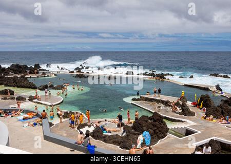Porto Moniz, Madeira - 7. Juli 2025; viele Touristen schwimmen in natürlichen Lavabecken. Pool mit Blick auf das Meer. Hochwertige Fotos Stockfoto