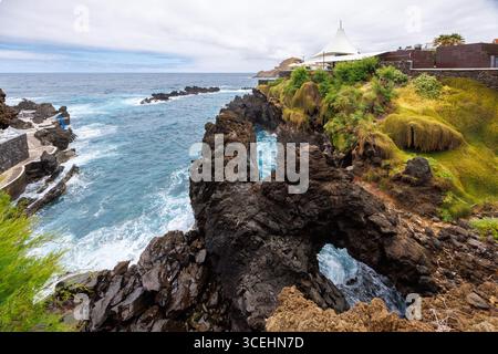 Porto Moniz, Madeira - 7. Juli 2025; türkisfarbenes Wasser des Atlantischen Ozeans stürzt gegen vulkanische Felsen, Schluchten in den Klippen. Hochwertige Fotos Stockfoto
