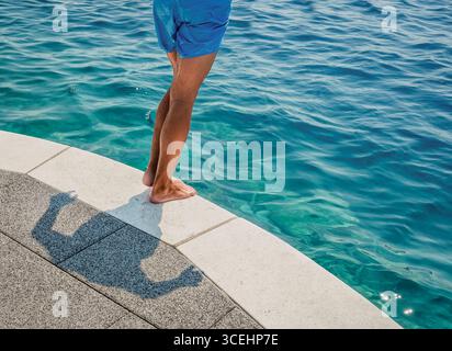 Mann, der am Rande steht, bevor er in die Adria eintaucht Kroatien Stockfoto