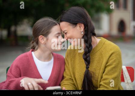 Zärtlicher Moment zwischen Mutter und Tochter, der sich an der Stirn berührt. Stockfoto