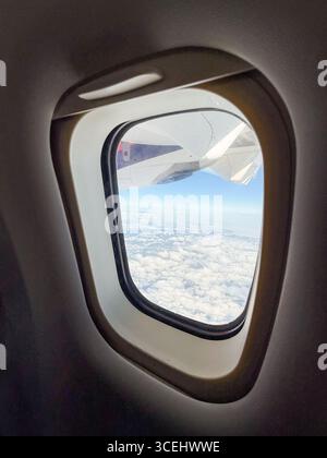 Ansicht vom Flugzeugfenster über grüne Felder unten. Luftfahrt, Flugerlebnis und Verbindung zwischen Himmel und Erde während der Reise. Stockfoto