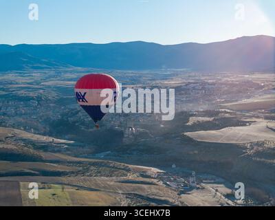 Segovia, Spanien - 26. Dezember 2023: Aus der Vogelperspektive eines pulsierenden Heißluftballons, der über die historische Stadt gleitet und eine fröhliche Silhouette gegen die wirft Stockfoto