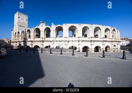 Römisches Amphitheater in Arles, Frankreich, unter einem klaren blauen Himmel mit seiner historischen Architektur und Bögen Stockfoto