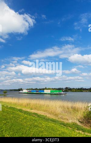 Binnenfrachttransport per Binnenschiff auf dem Lek River in der Nähe von Lopik in Utrecht, Niederlande, am schönen Frühlingstag Stockfoto