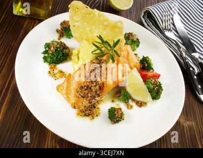Gegrilltes Lachssteak mit Broccoli, Kartoffelpüree Käsekracker auf Holzhintergrund Stockfoto