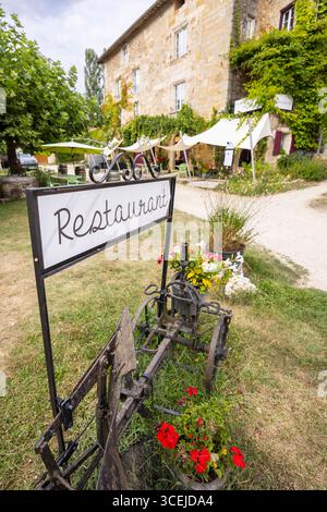 Charmantes Restaurantschild mit altem Pflug in Saint Jean de Cole, Dordogne, Nouvelle Aquitaine, Frankreich, das die Gäste einlädt, lokale Küche zu genießen Stockfoto